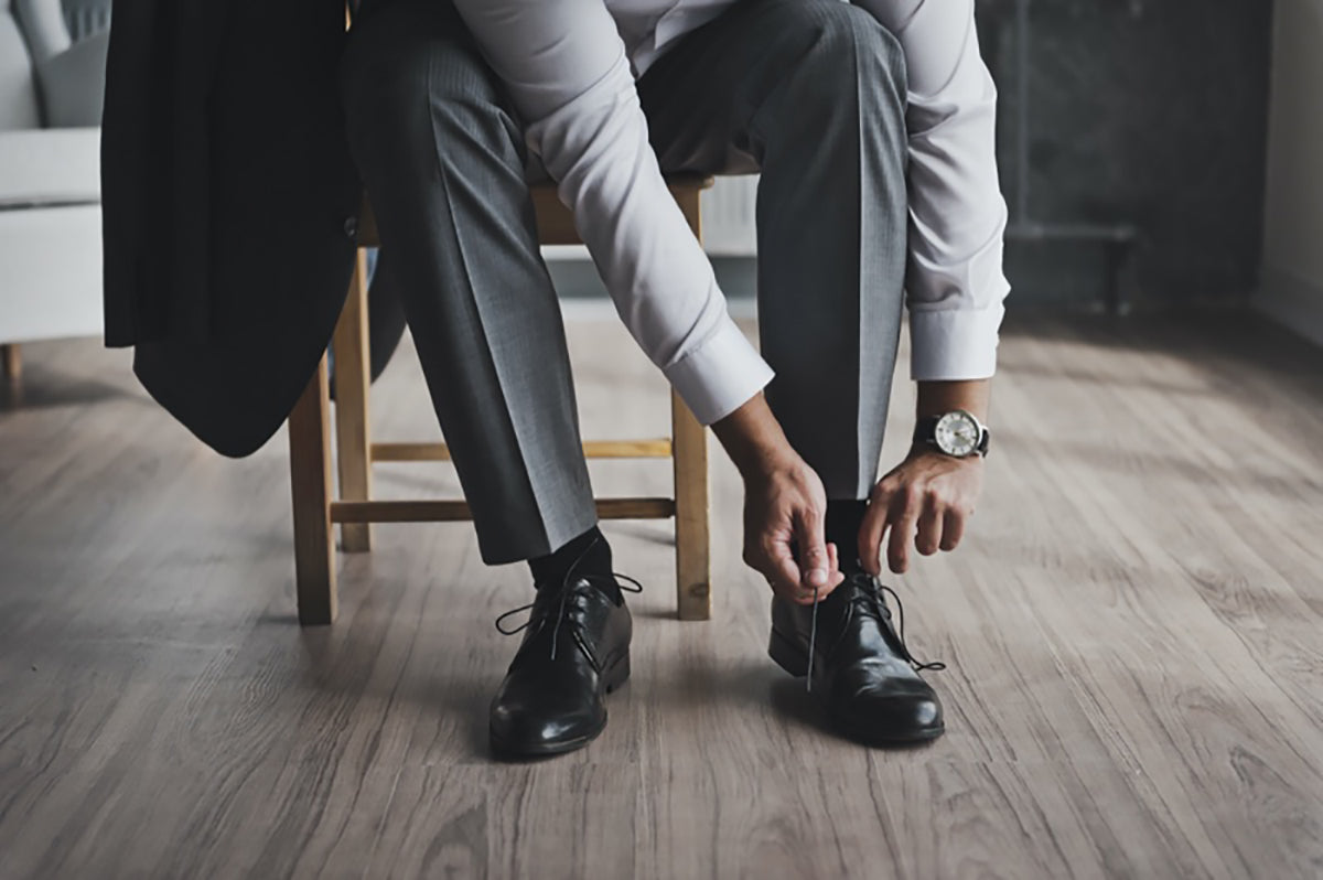 Man Tying his Dress Shoe on chair